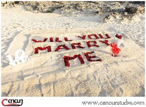 Will you Marry Me letters in th sand with Rose Petals